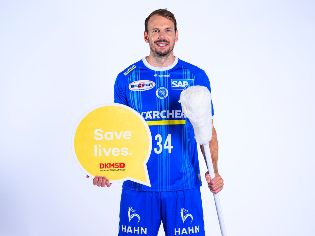 Ein Mann hält ein Schild und einen Stock Ein Mann hält ein Schild und einen Stock