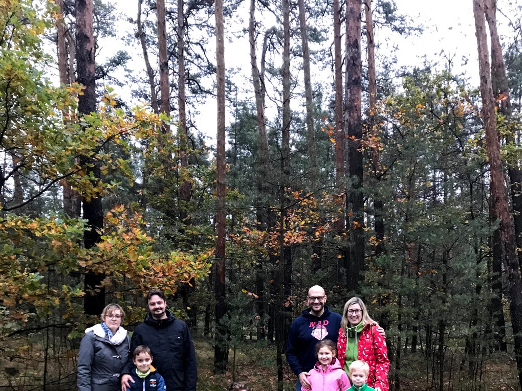 Checker Tobi mit beiden Familien, sie posieren vor einem Wald Checker Tobi mit beiden Familien, sie posieren vor einem Wald