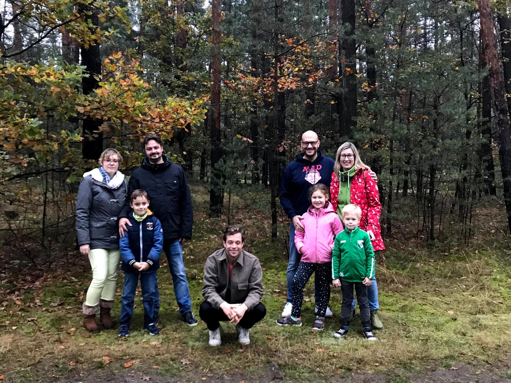 Checker Tobi mit beiden Familien, sie posieren vor einem Wald Checker Tobi mit beiden Familien, sie posieren vor einem Wald