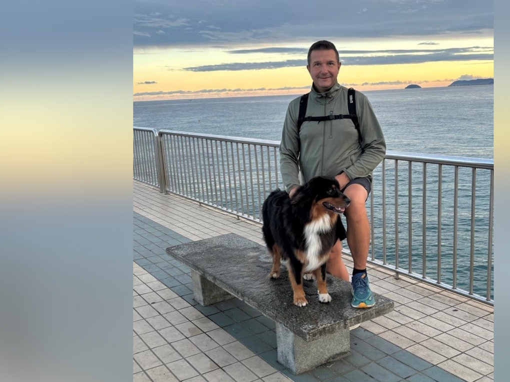 Ein Mann steht mit einem Hund vorm Meer. Ein Mann steht mit einem Hund vorm Meer.