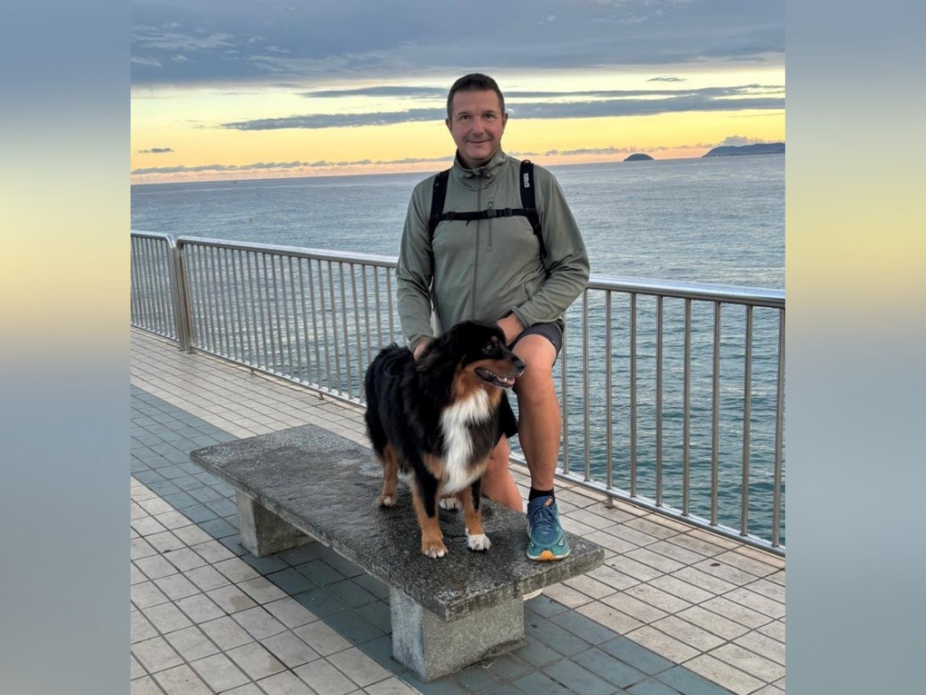 Ein Mann steht mit einem Hund vorm Meer. Ein Mann steht mit einem Hund vorm Meer.