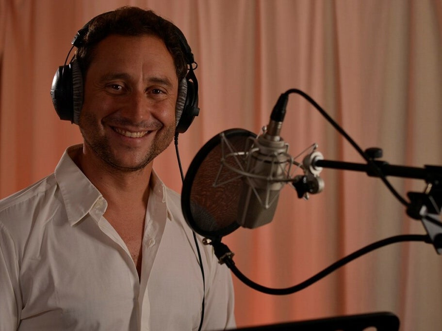 Christian Rex, der Kopfhörer trägt und vor einem Mikrofon steht Christian Rex, der Kopfhörer trägt und vor einem Mikrofon steht