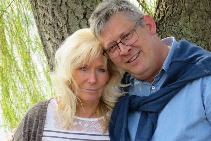 Blutkrebspatient Andreas mit seiner Frau Petra im Wald, beide lächeln in die Kamera.