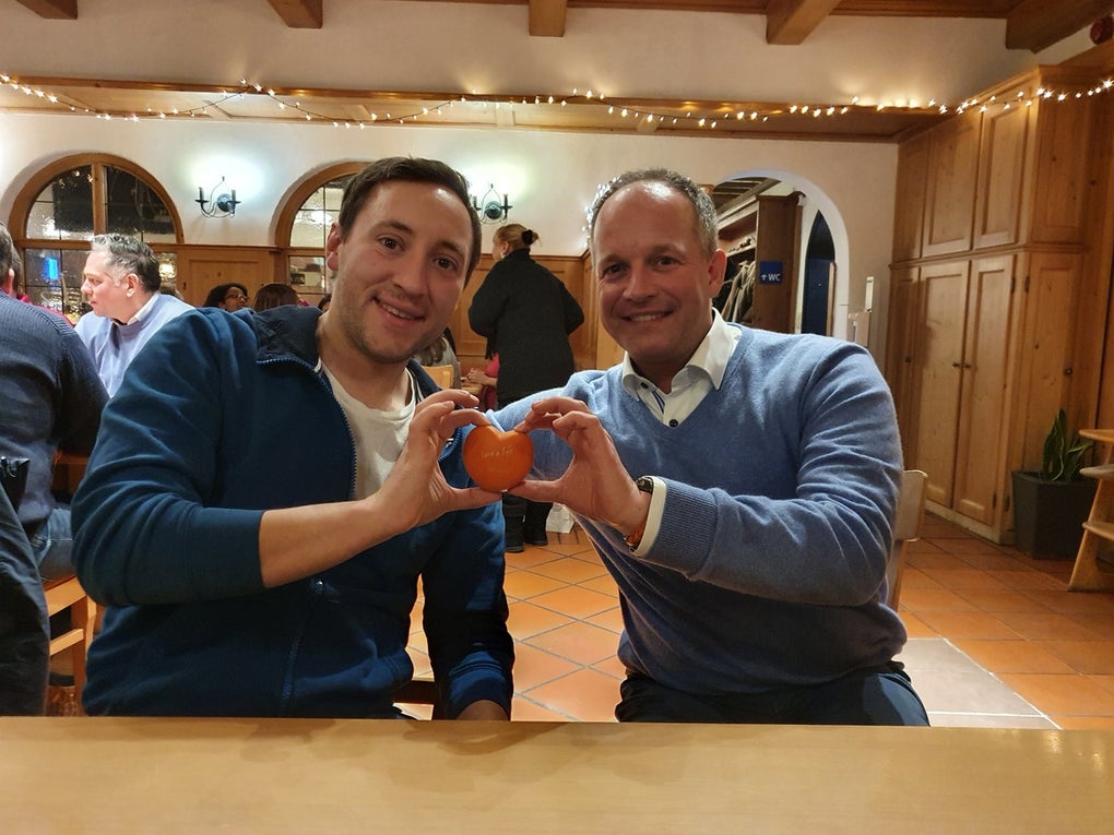 Zwei Männer halten gemeinsam ein Herz hoch Zwei Männer halten gemeinsam ein Herz hoch