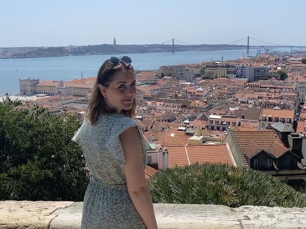 Eine Frau steht auf einem Felsvorsprung mit Blick auf eine Stadt Eine Frau steht auf einem Felsvorsprung mit Blick auf eine Stadt