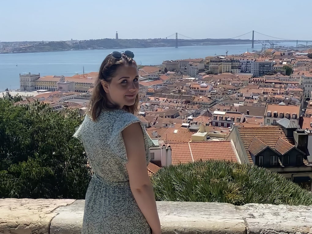 Eine Frau steht auf einem Felsvorsprung mit Blick auf eine Stadt Eine Frau steht auf einem Felsvorsprung mit Blick auf eine Stadt