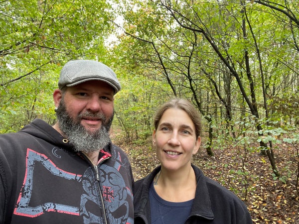 Ein Mann und Marina stehen in einem Wald Ein Mann und Marina stehen in einem Wald
