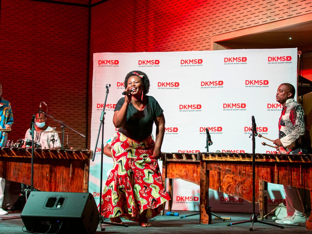 Die Marimba Band begleitete den Start von DKMS Africa, eine Frau sing in ein Mikrofon  Die Marimba Band begleitete den Start von DKMS Africa, eine Frau sing in ein Mikrofon