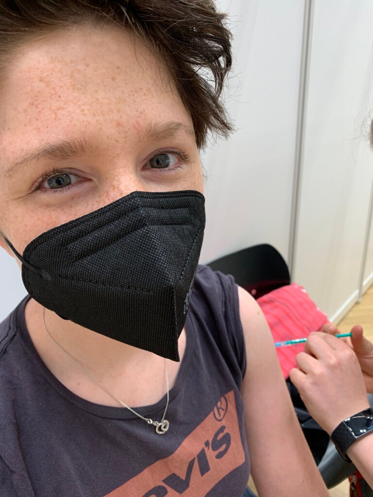 Vanessa trägt eine schwarze Gesichtsmaske und wird geimpft Vanessa trägt eine schwarze Gesichtsmaske und wird geimpft