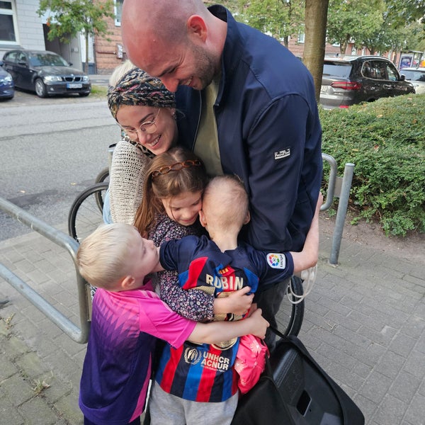 Ein Mann und eine Frau, die Kinder umarmen Ein Mann und eine Frau, die Kinder umarmen