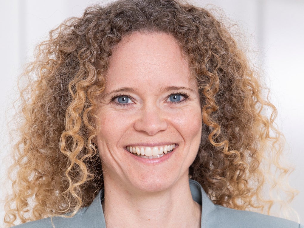 Eine Frau mit lockigem Haar lächelt Eine Frau mit lockigem Haar lächelt