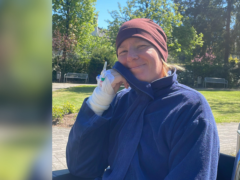 Eine Frau, die mit einer bandagierten Hand lächelt Eine Frau, die mit einer bandagierten Hand lächelt