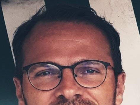 ein Mann mit Bart und Brille lächelt in die Kamera ein Mann mit Bart und Brille lächelt in die Kamera