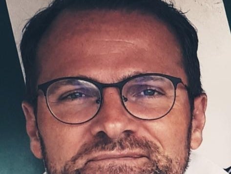 ein Mann mit Bart und Brille lächelt in die Kamera ein Mann mit Bart und Brille lächelt in die Kamera