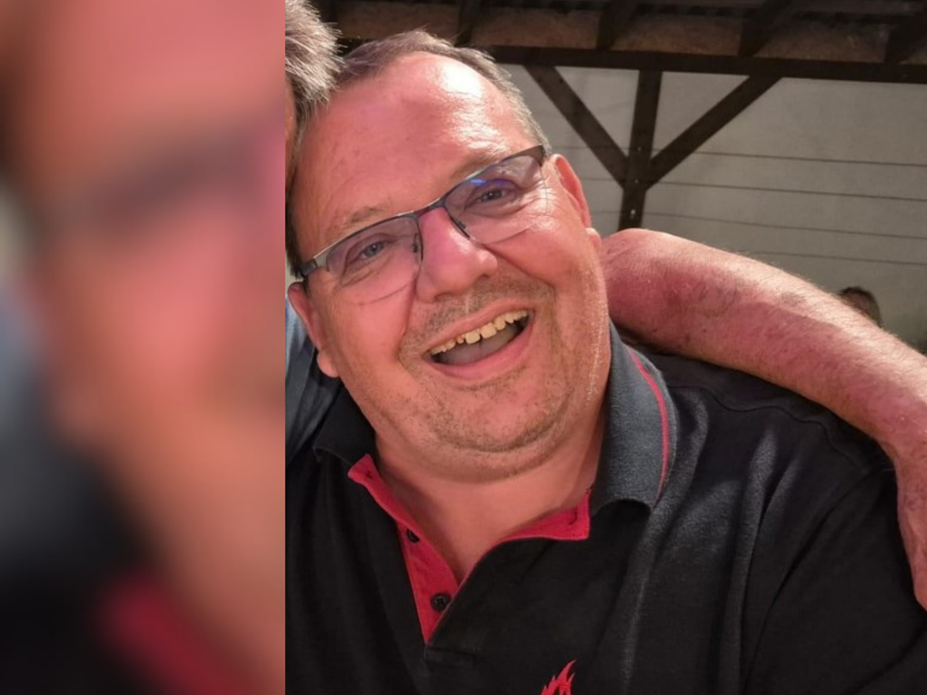 Ein Mann lacht und trägt ein schwarzes Polo-Shirt mit der Aufschrift "Feuerwehr Bruchsal". Ein Mann lacht und trägt ein schwarzes Polo-Shirt mit der Aufschrift "Feuerwehr Bruchsal".