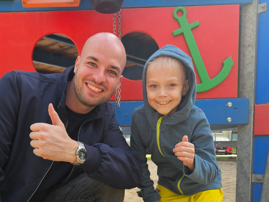 Ein Mann und ein Junge posieren für ein Foto Ein Mann und ein Junge posieren für ein Foto