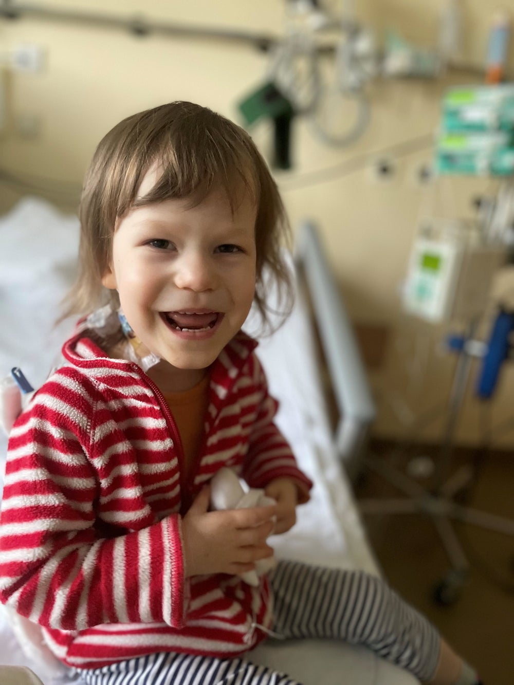 Patientin Svea sitzt im Krankenhausbett und lächelt
