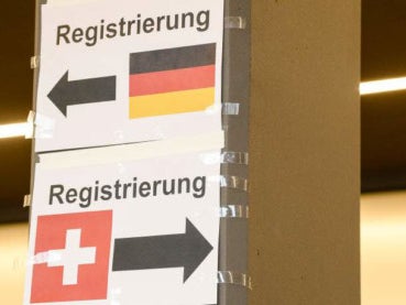 Zwei Schilder mit der Deutschen und Schweizer Flagge, beide mit dem Aufdruck Registrierung und Pfeilen die jeweils in unterschiedliche Richtungen zeigen Zwei Schilder mit der Deutschen und Schweizer Flagge, beide mit dem Aufdruck Registrierung und Pfeilen die jeweils in unterschiedliche Richtungen zeigen