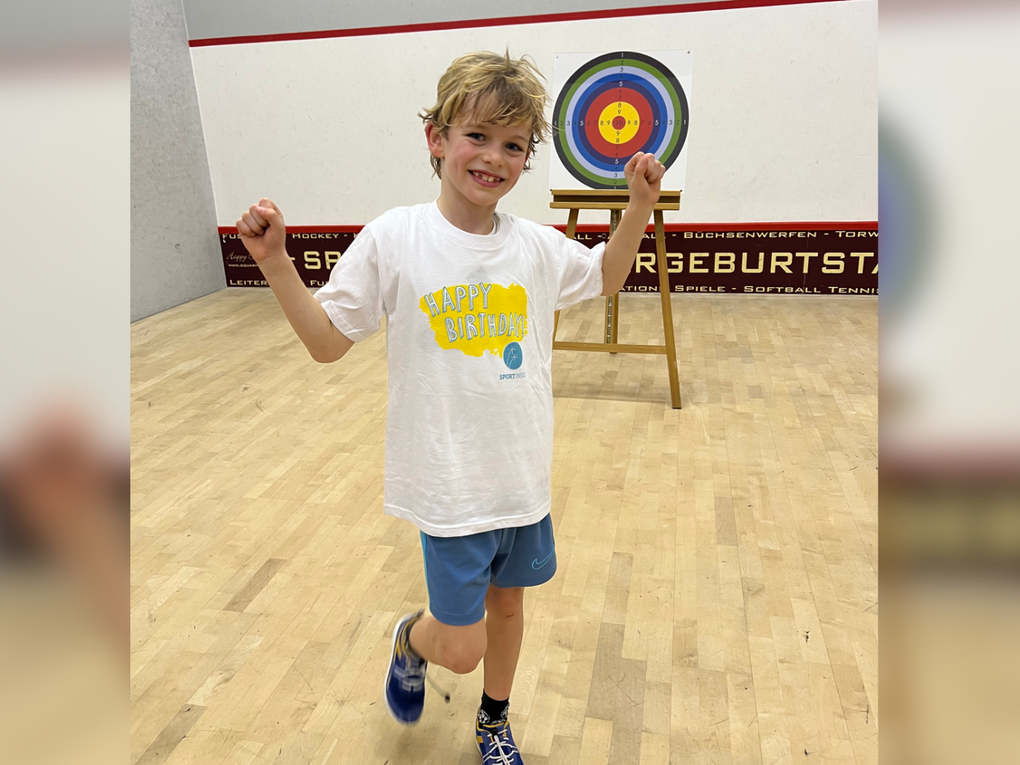 Ein Junge in einem weißen Hemd und blauen Shorts Ein Junge in einem weißen Hemd und blauen Shorts