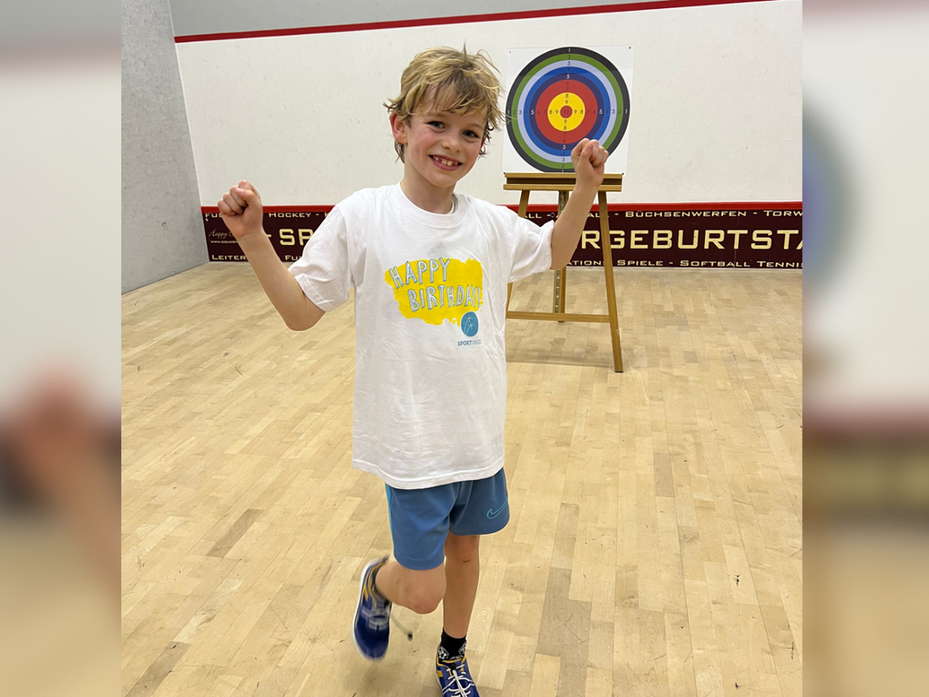 Ein Junge in einem weißen Hemd und blauen Shorts Ein Junge in einem weißen Hemd und blauen Shorts