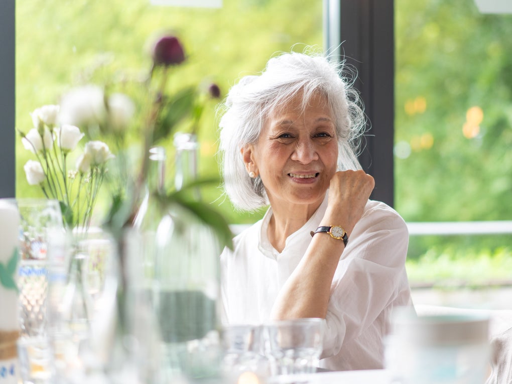 Eine ältere Frau lächelt in die Kamera Eine ältere Frau lächelt in die Kamera