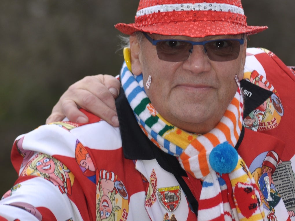 Ein Mann mit einem rot-weiß gestreiften Hut und einer Sonnenbrille posiert für ein Foto Ein Mann mit einem rot-weiß gestreiften Hut und einer Sonnenbrille posiert für ein Foto