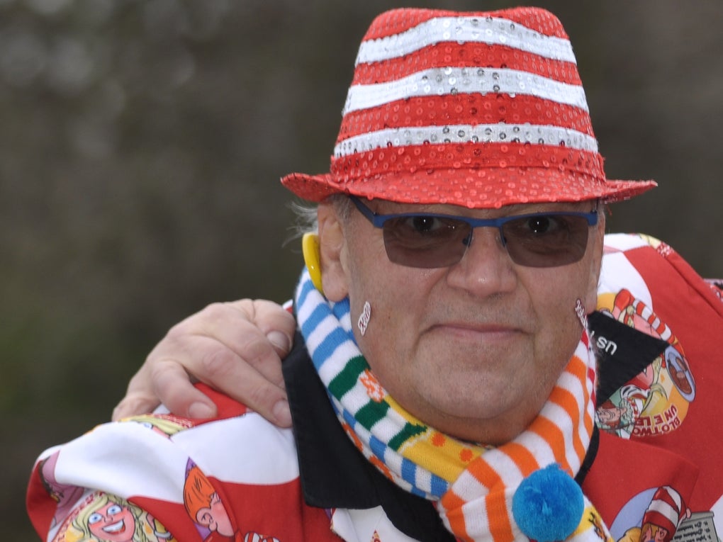 Ein Mann mit einem rot-weiß gestreiften Hut und einer Sonnenbrille posiert für ein Foto Ein Mann mit einem rot-weiß gestreiften Hut und einer Sonnenbrille posiert für ein Foto