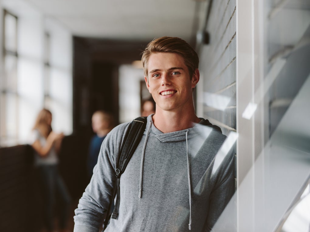 Ein Schüler steht in einem Korridor Ein Schüler steht in einem Korridor