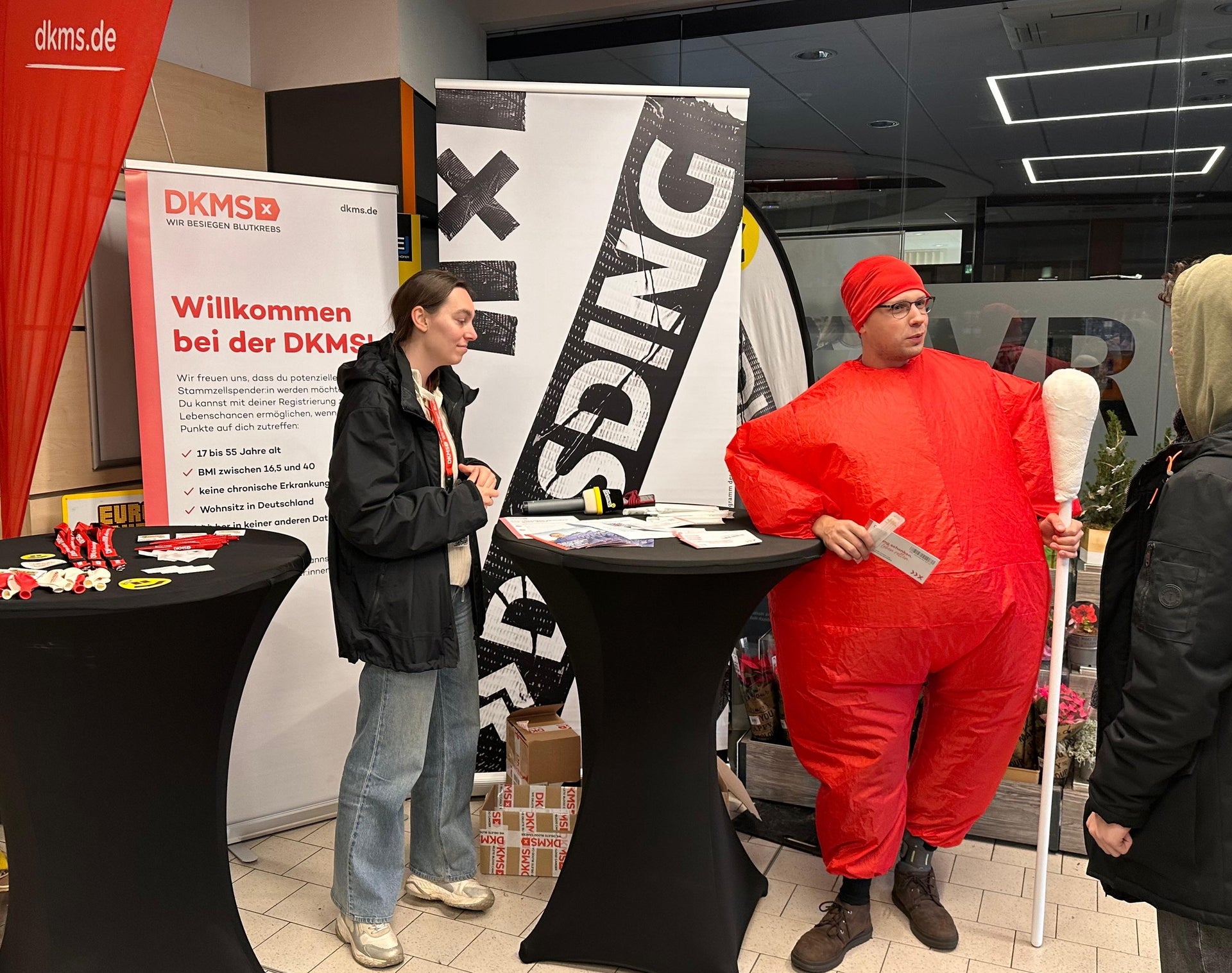 Ein Mann in einem Kleidungsstück steht neben einer Frau Ein Mann in einem Kleidungsstück steht neben einer Frau