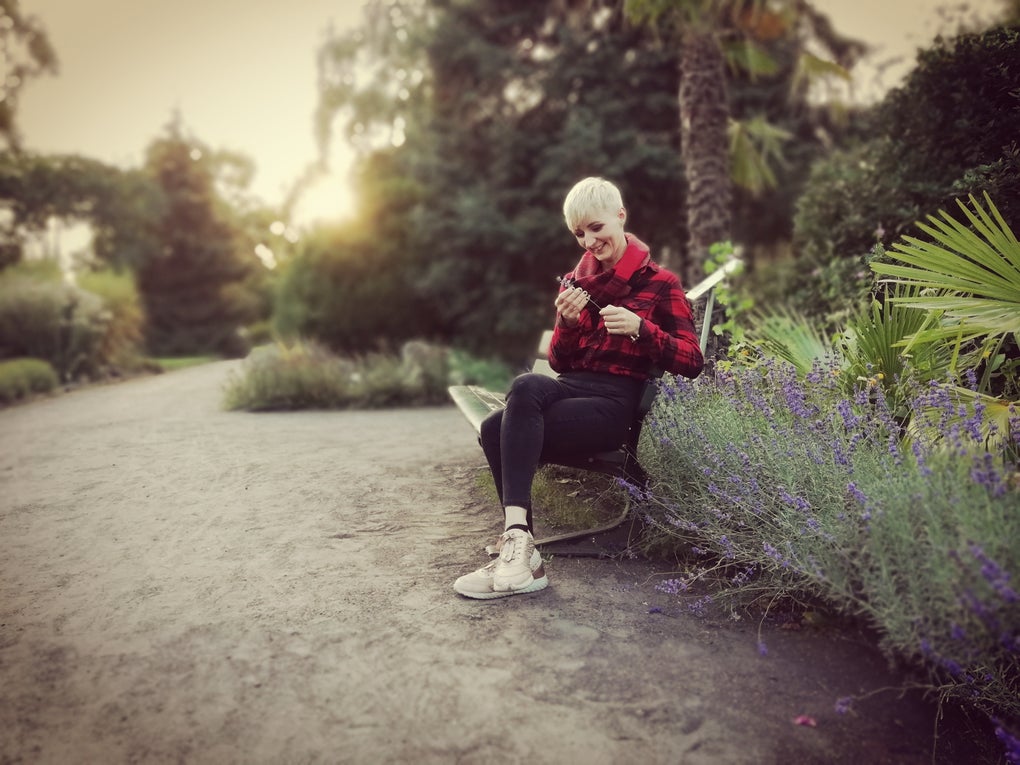 Henrike Oetken sitzt auf einer Bank und hält etwas in der Hand Henrike Oetken sitzt auf einer Bank und hält etwas in der Hand