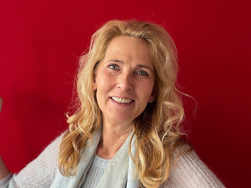 Eine Frau hält einen goldenen Preis hoch und lächelt in die Kamera Eine Frau hält einen goldenen Preis hoch und lächelt in die Kamera