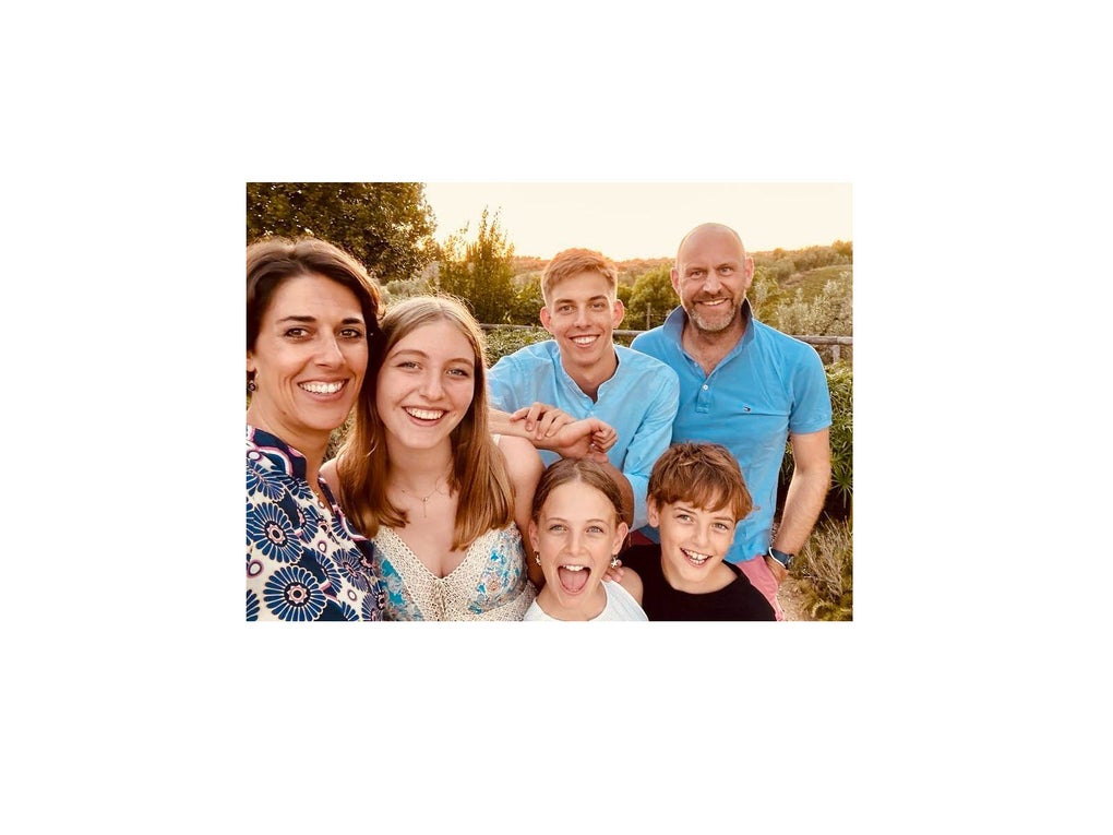 Eine Familie steht in Sommerkleidung im Grünen und lächelt in die Kamera. Eine Familie steht in Sommerkleidung im Grünen und lächelt in die Kamera.