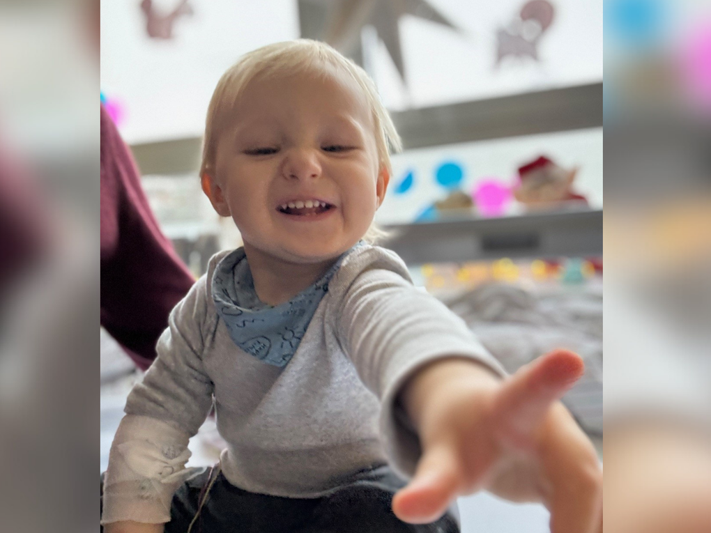 Ein lachendes Kleinkind hält den Zeigefinger in Richtung der Kamera. Ein lachendes Kleinkind hält den Zeigefinger in Richtung der Kamera.