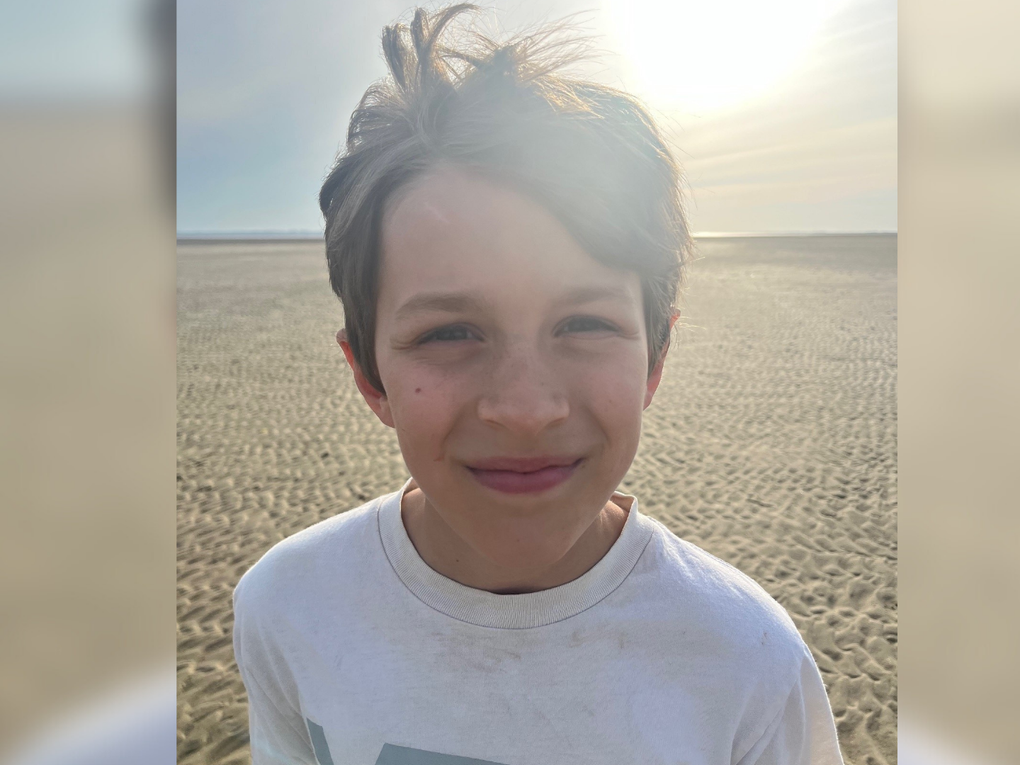 Ein Junge steht am Strand und lacht in die Kamera. Ein Junge steht am Strand und lacht in die Kamera.