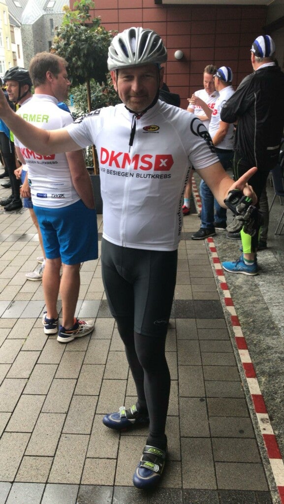 Ein Mann in Fahrradkleidung. Auf seinem Oberteil ist ein DKMS Logo gedruckt Ein Mann in Fahrradkleidung. Auf seinem Oberteil ist ein DKMS Logo gedruckt