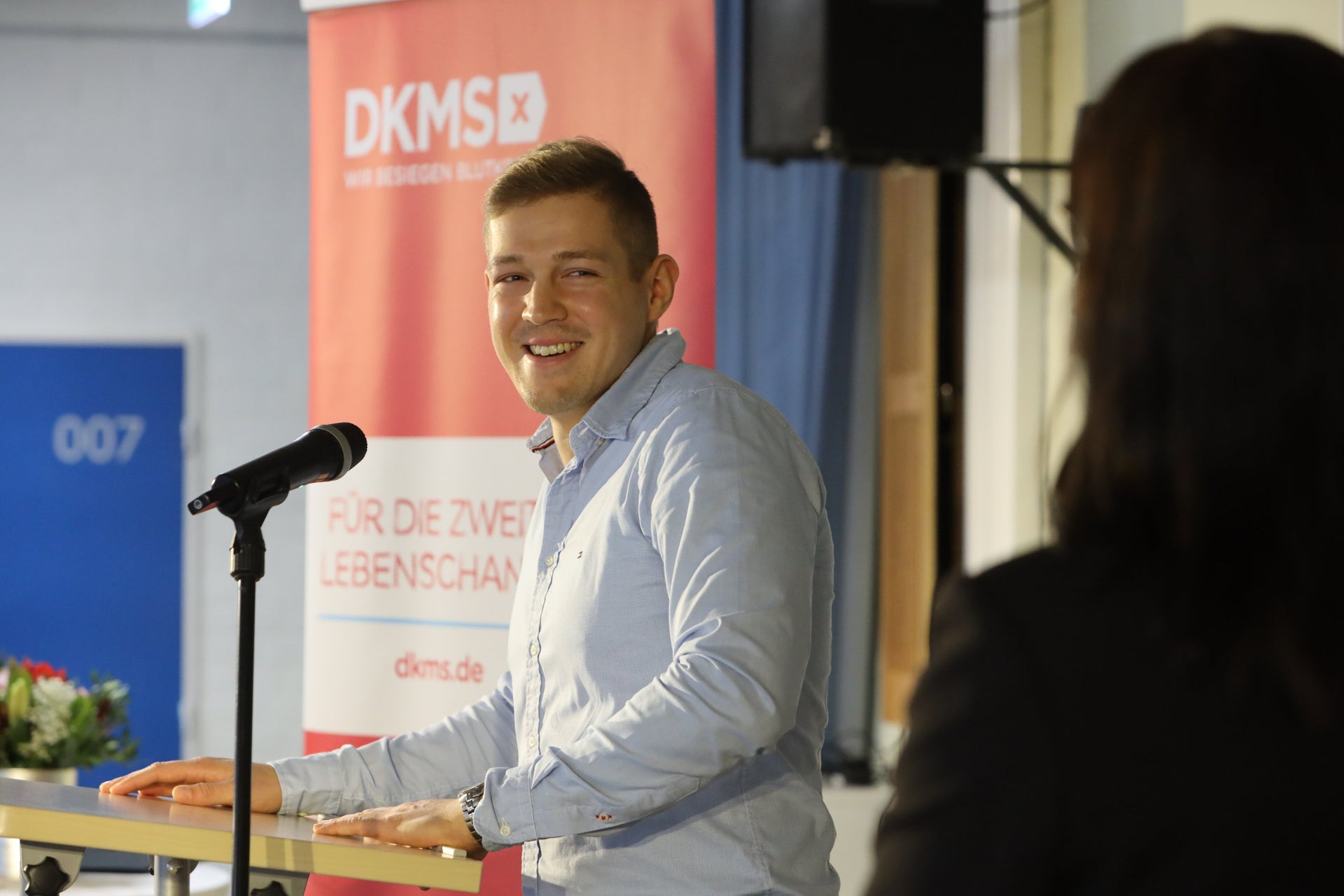 Ein Mann steht an einem Podium mit einem Mikrofon Ein Mann steht an einem Podium mit einem Mikrofon