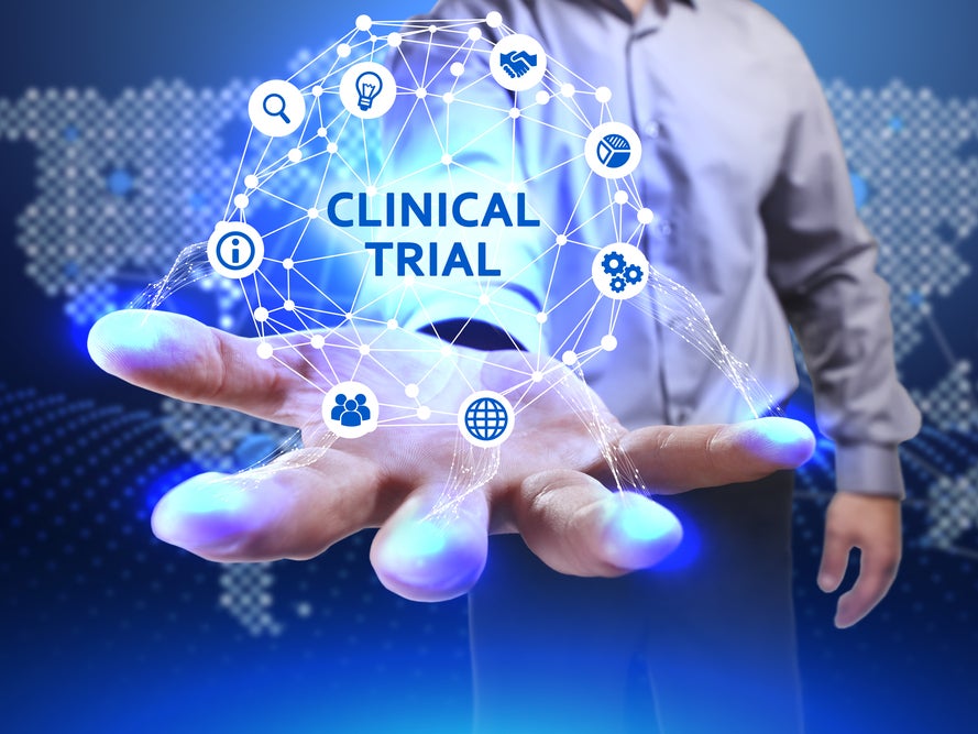 Eine Person, die eine leuchtende Kugel mit Symbolen in der Hand hält. In der Mitte steht Clinical Trial Eine Person, die eine leuchtende Kugel mit Symbolen in der Hand hält. In der Mitte steht Clinical Trial