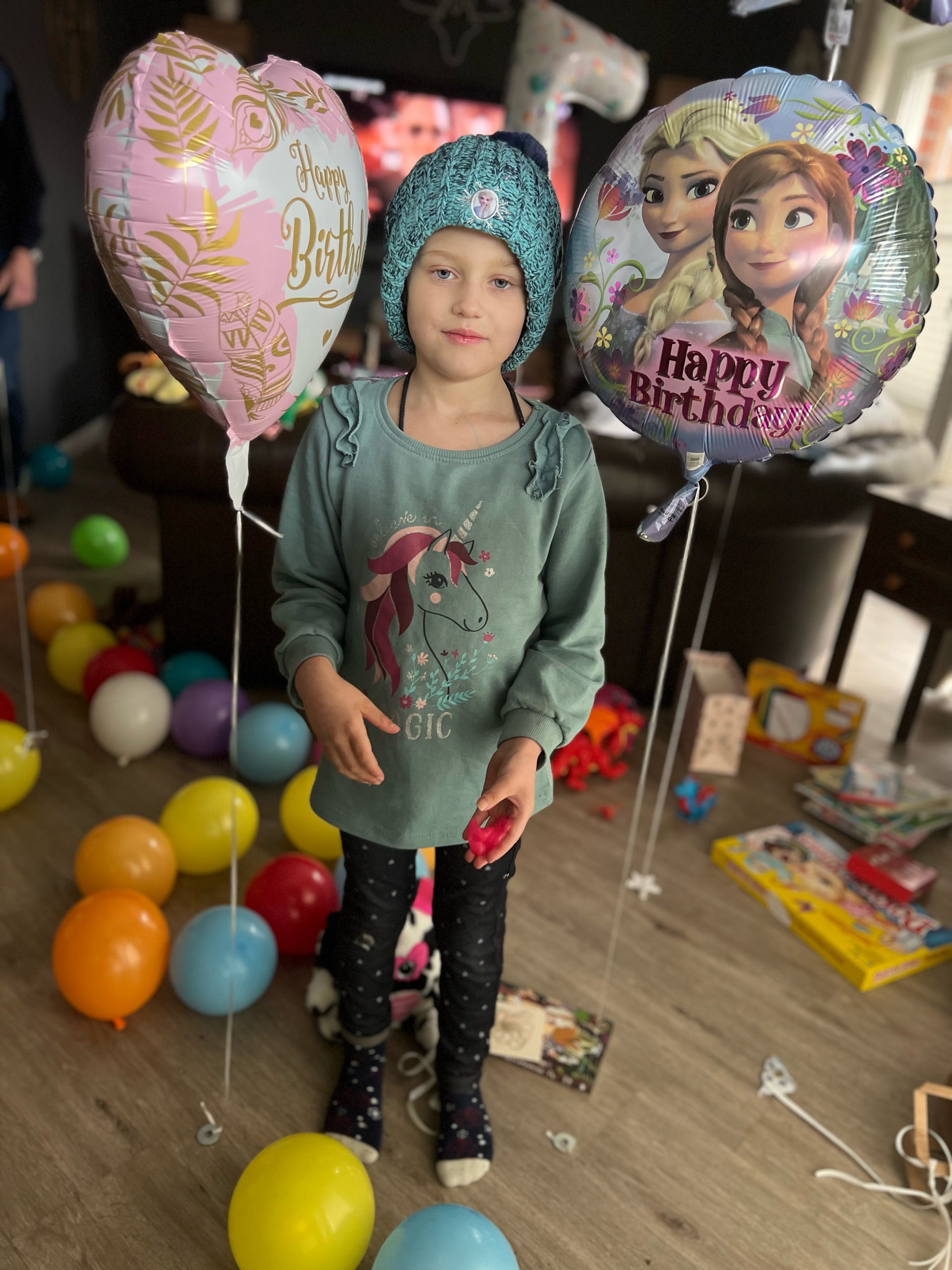 Ein Kind steht zwischen Geburtstags-Luftballons Ein Kind steht zwischen Geburtstags-Luftballons