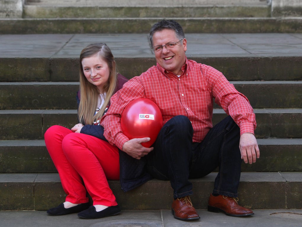 Ein Mann und ein Mädchen sitzen auf einer Treppe und halten einen Luftballon Ein Mann und ein Mädchen sitzen auf einer Treppe und halten einen Luftballon