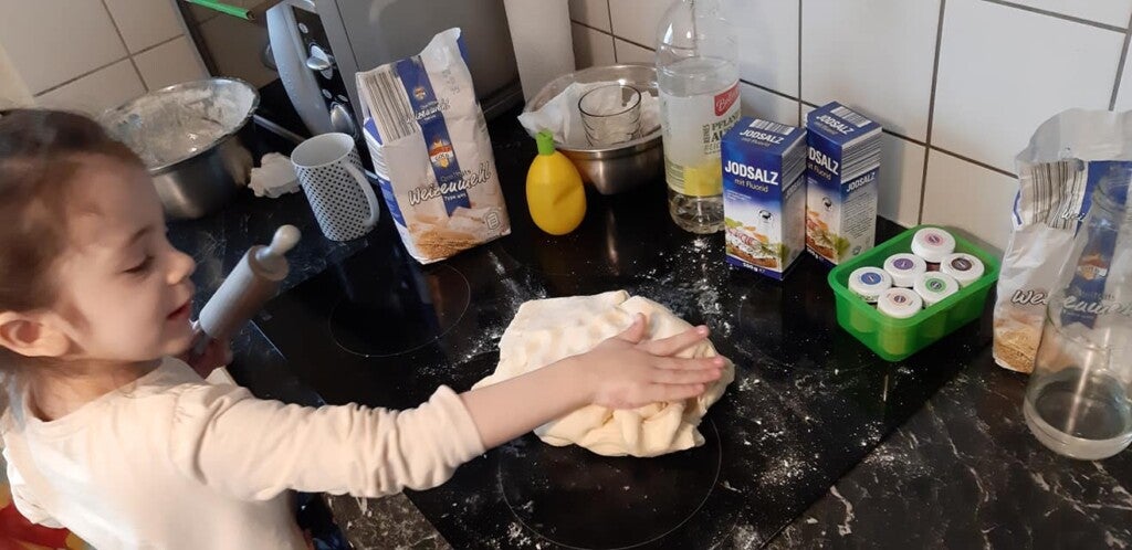 Ein Kind macht Teig auf einem Herd Ein Kind macht Teig auf einem Herd