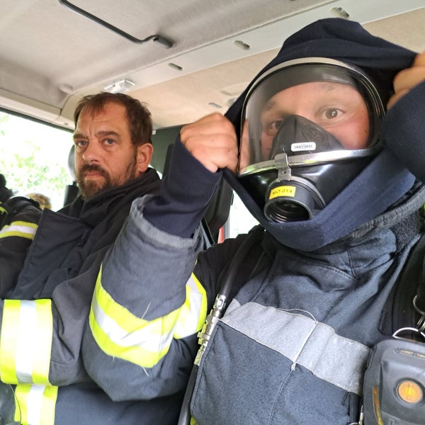 Patient Simon in Ausrüstung, mit einem Kollegen im Feuerwehrauto.