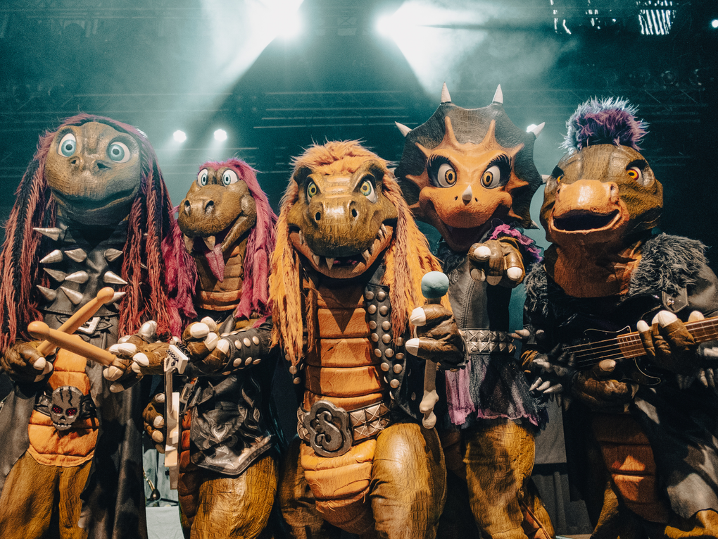 Eine Gruppe von Menschen in Dinosaurierverkleidung mit Instrumenten. Eine Gruppe von Menschen in Dinosaurierverkleidung mit Instrumenten.