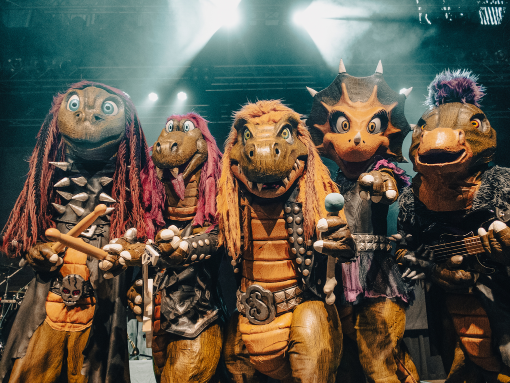 Eine Gruppe von Menschen in Dinosaurierverkleidung mit Instrumenten. Eine Gruppe von Menschen in Dinosaurierverkleidung mit Instrumenten.