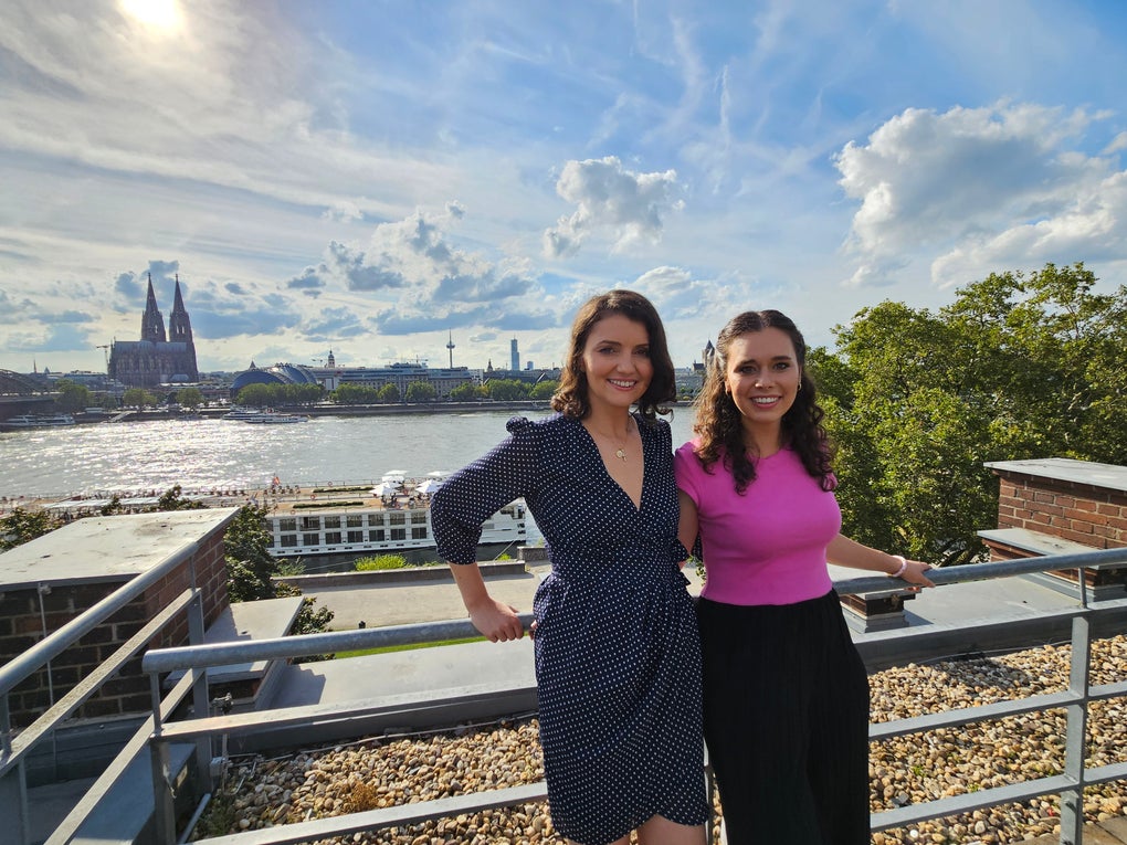 Zwei Frauen posieren für ein Foto, im Hintergrund sieht man den Rhein und den Kölner Dom Zwei Frauen posieren für ein Foto, im Hintergrund sieht man den Rhein und den Kölner Dom