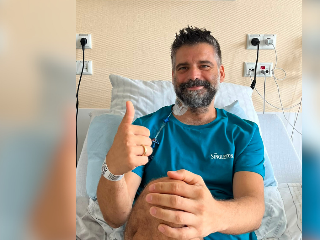 Ein Mann sitzt in einem Krankenhausbett und hält den Daumen nach oben. Ein Mann sitzt in einem Krankenhausbett und hält den Daumen nach oben.