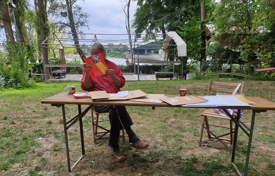 Klaus sitzt an einem Tisch auf dem Umschläge und Papiere liegen Klaus sitzt an einem Tisch auf dem Umschläge und Papiere liegen