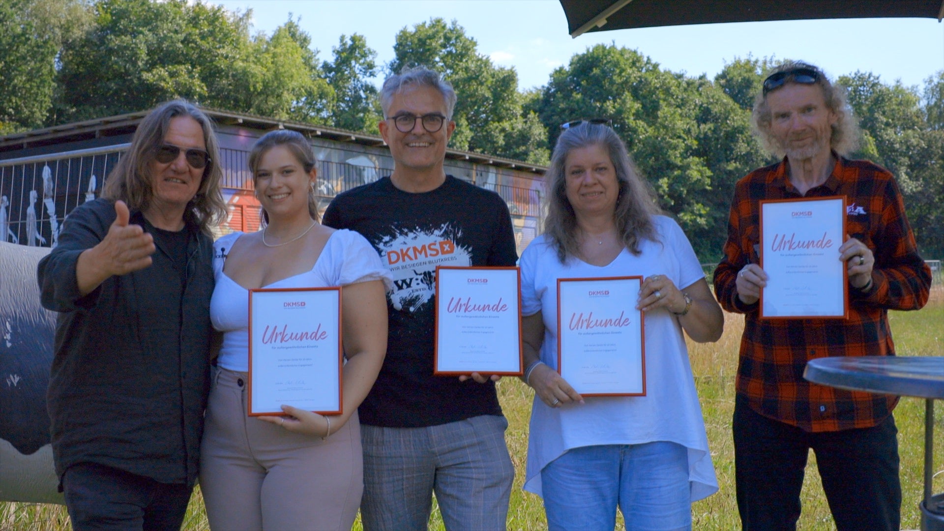 Eine Gruppe von Menschen, die Zertifikate hochhalten Eine Gruppe von Menschen, die Zertifikate hochhalten
