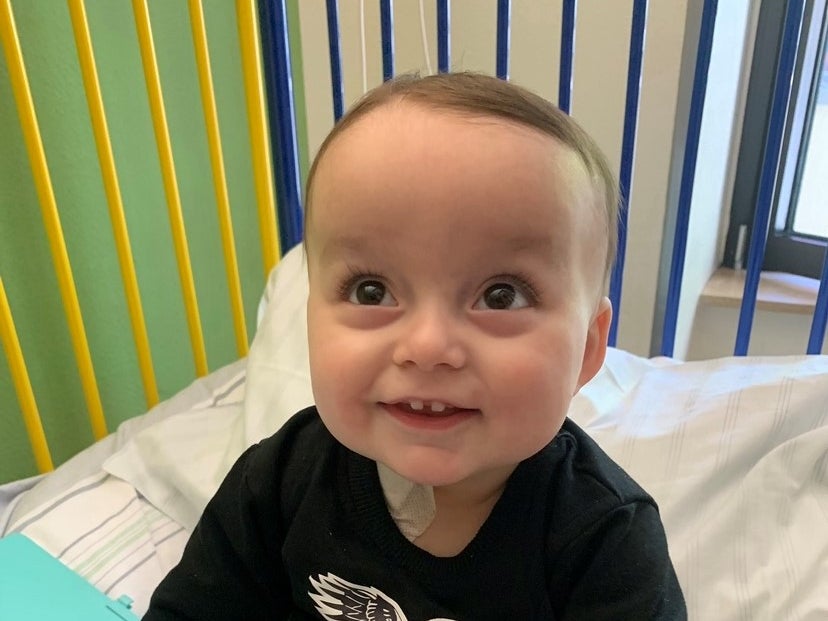 kleines Kind sitzt auf einem Krankenhausbett und lächelt in die Kamera kleines Kind sitzt auf einem Krankenhausbett und lächelt in die Kamera