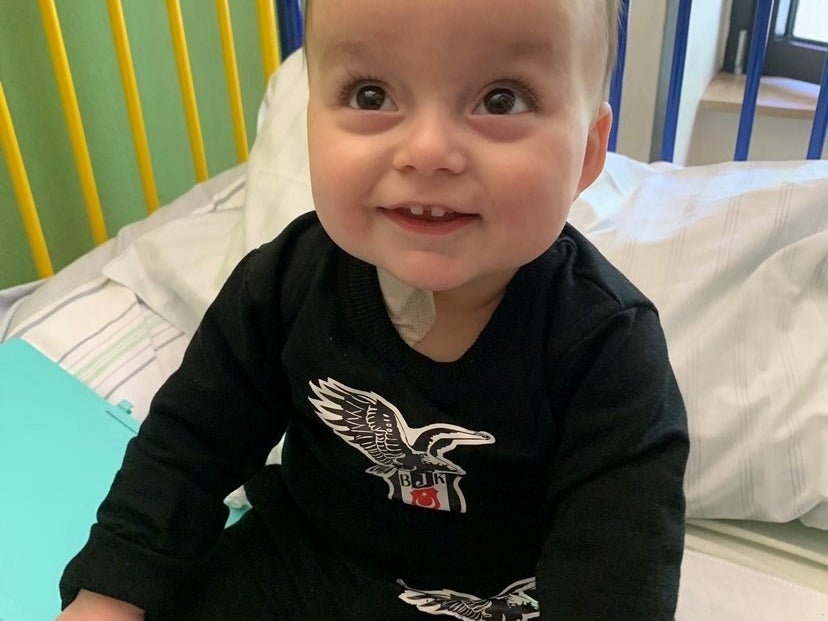 kleines Kind sitzt auf einem Krankenhausbett und lächelt in die Kamera kleines Kind sitzt auf einem Krankenhausbett und lächelt in die Kamera