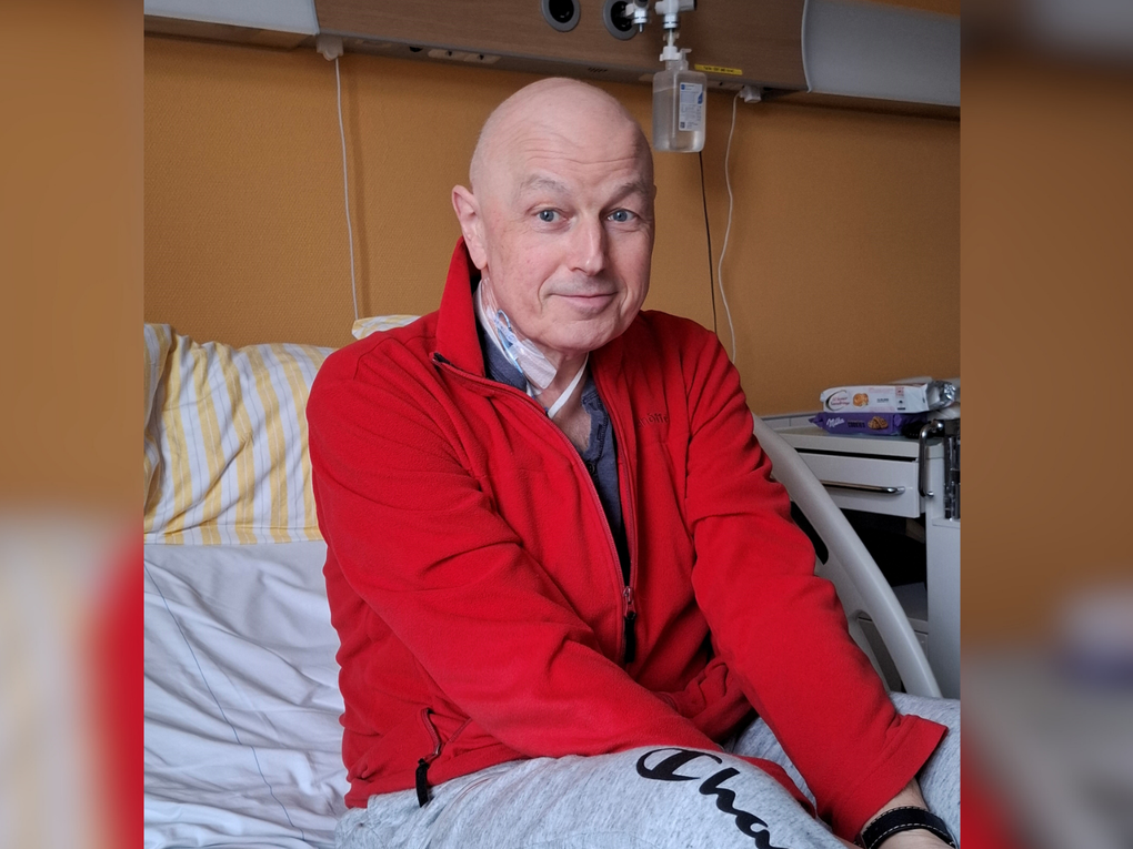 Ein Mann sitzt in einem Krankenhausbett Ein Mann sitzt in einem Krankenhausbett